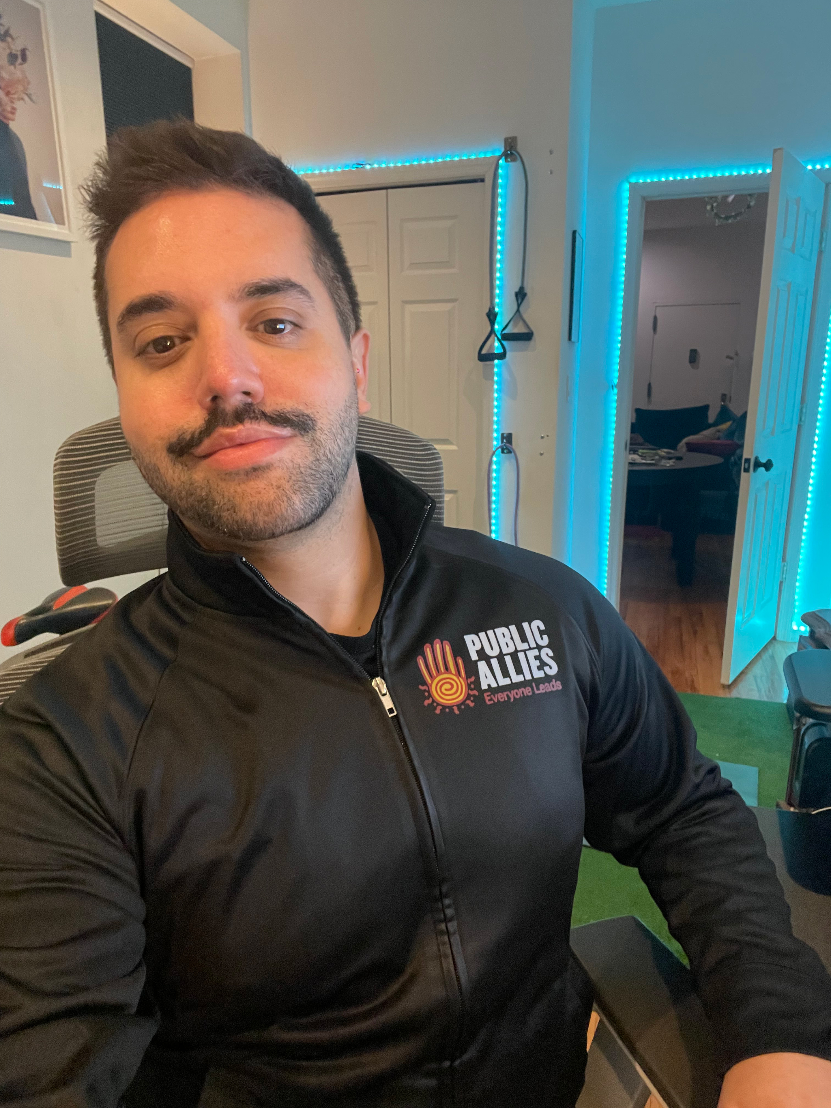 A photo shows Andy Stone sitting at home.