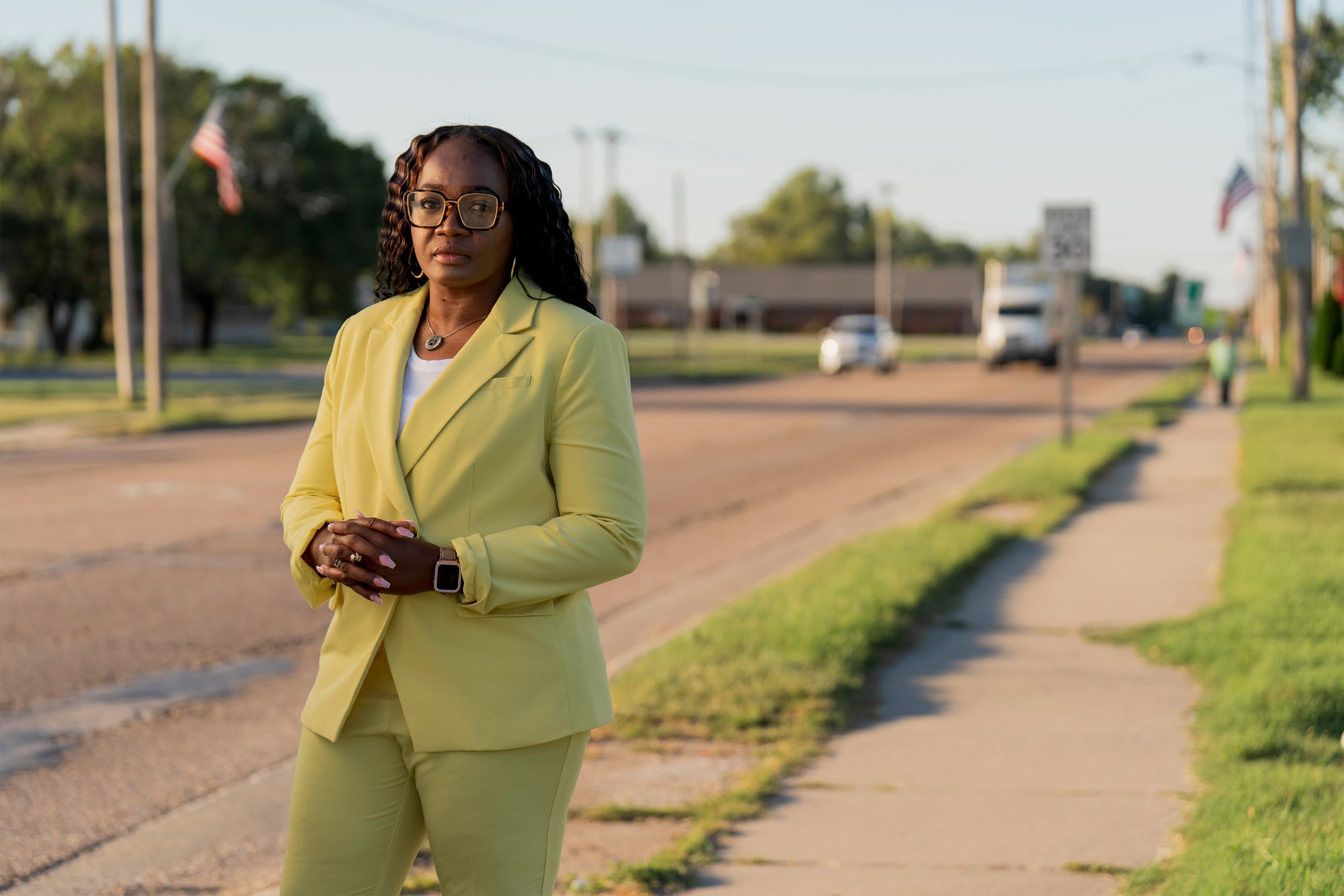 April Roby-Bell poses for a portrait outside on the sidewalk in Washington Park, Illinois.