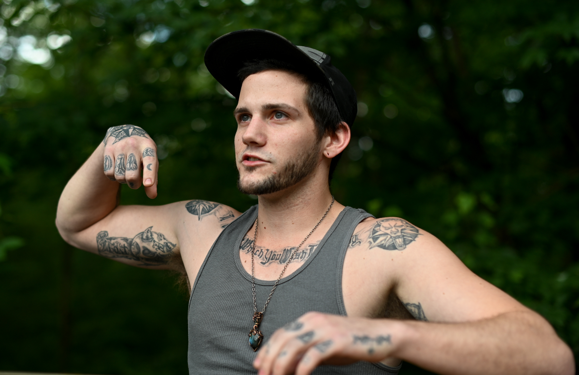 By motioning with his arms, Adam Caprioli describes being shot in the back with a pepper-spray launcher while having a mental health crisis.