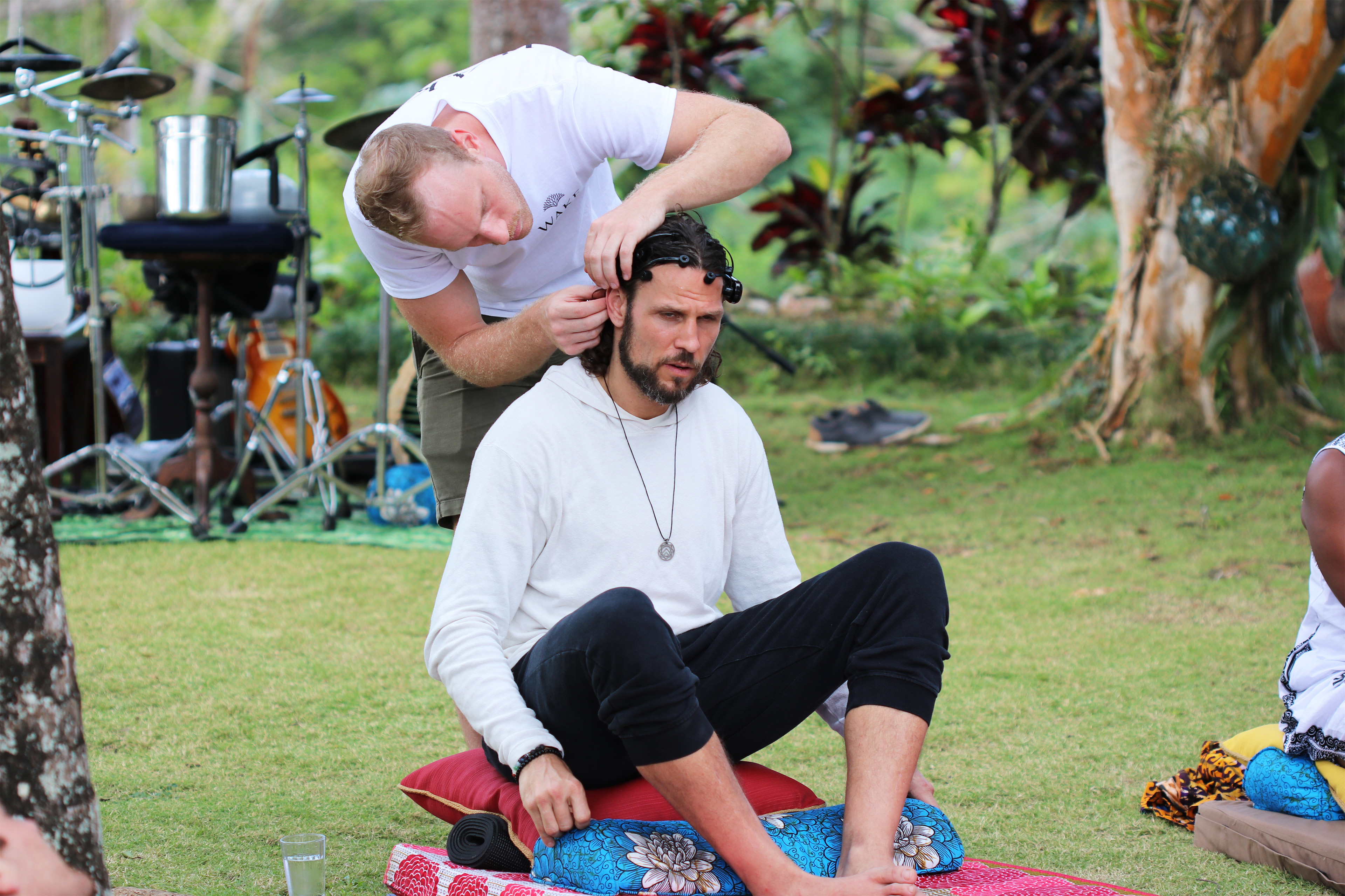 A photo of a Riley Cote sitting on a mat outside while someone attached a device to his head.