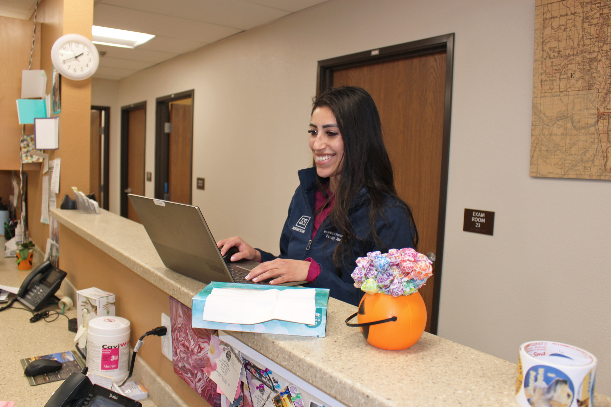 A photo of Dr. Martinez working on a laptop.