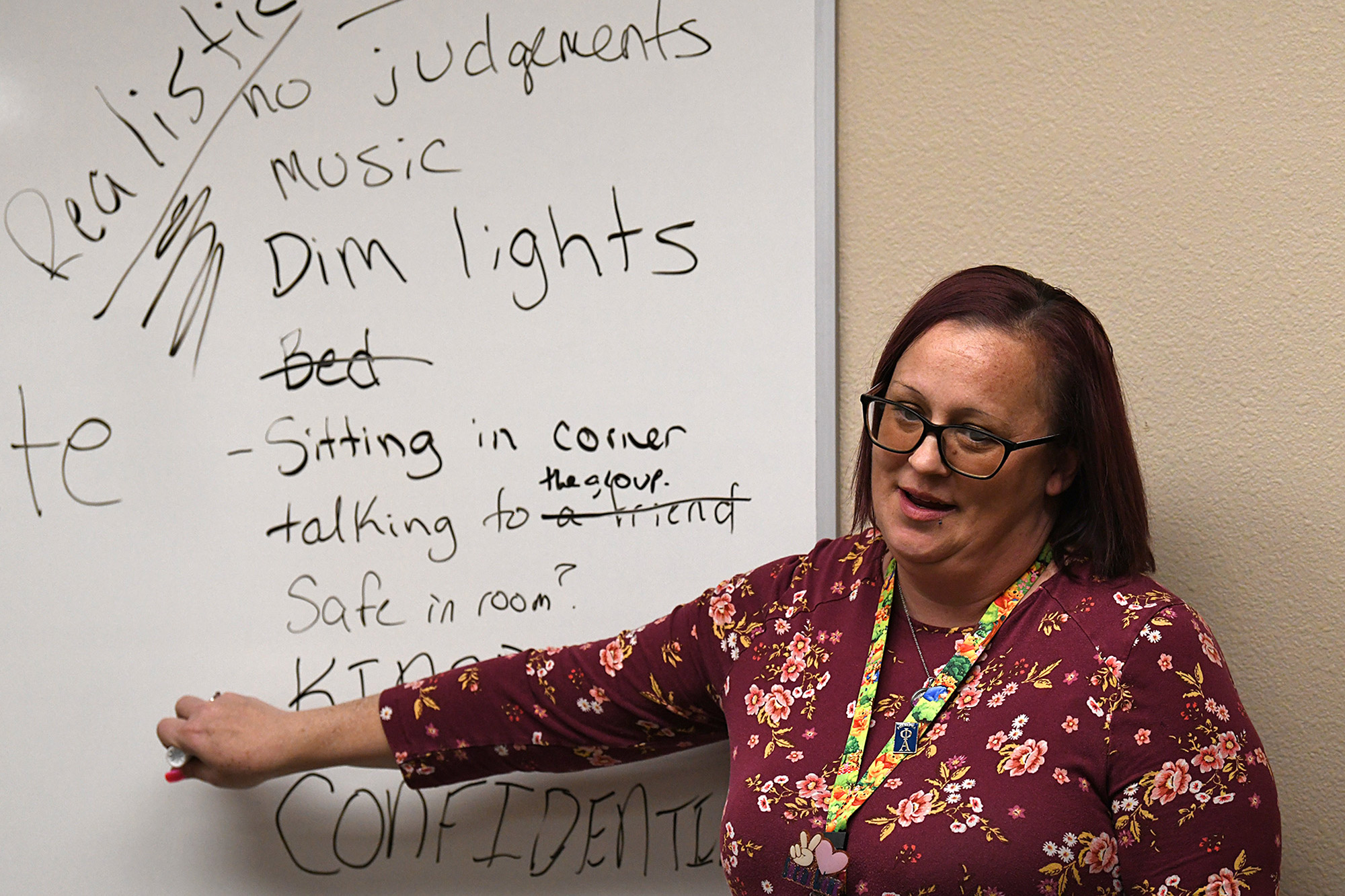 A photo of a therapist pointing to whiteboard.