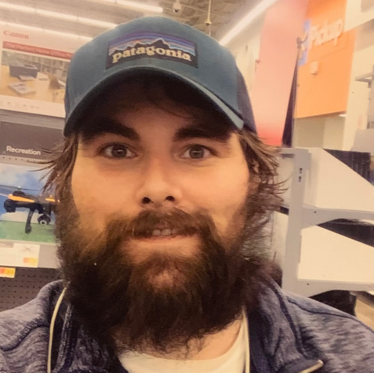 A photo of a man wearing a baseball cap indoors.