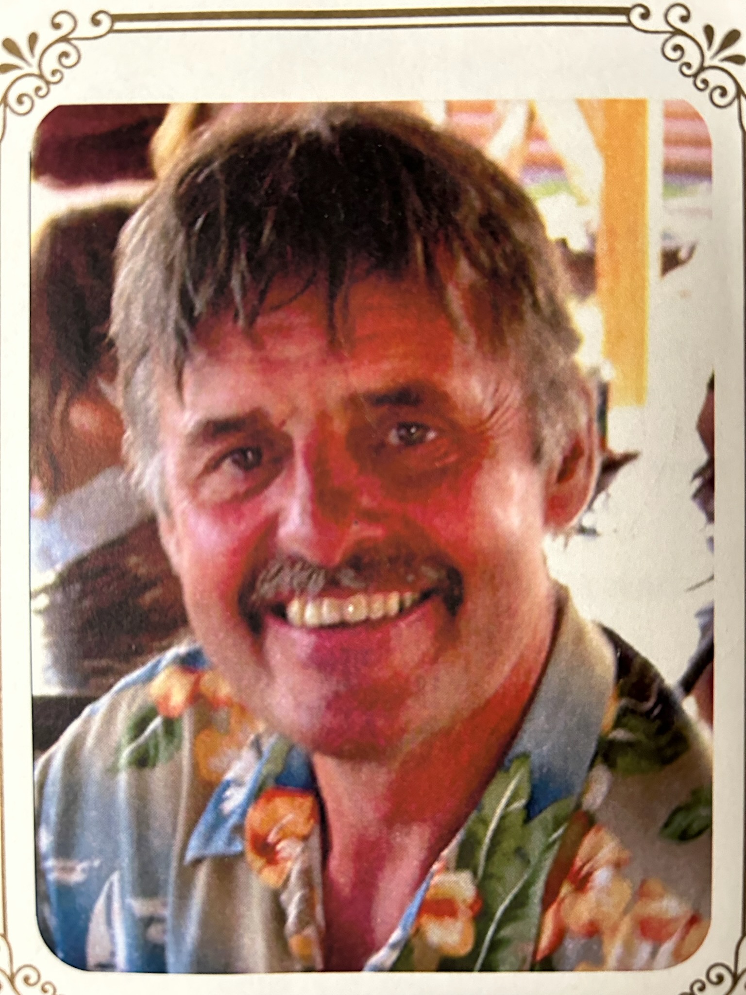 A smiling man looks at the camera.