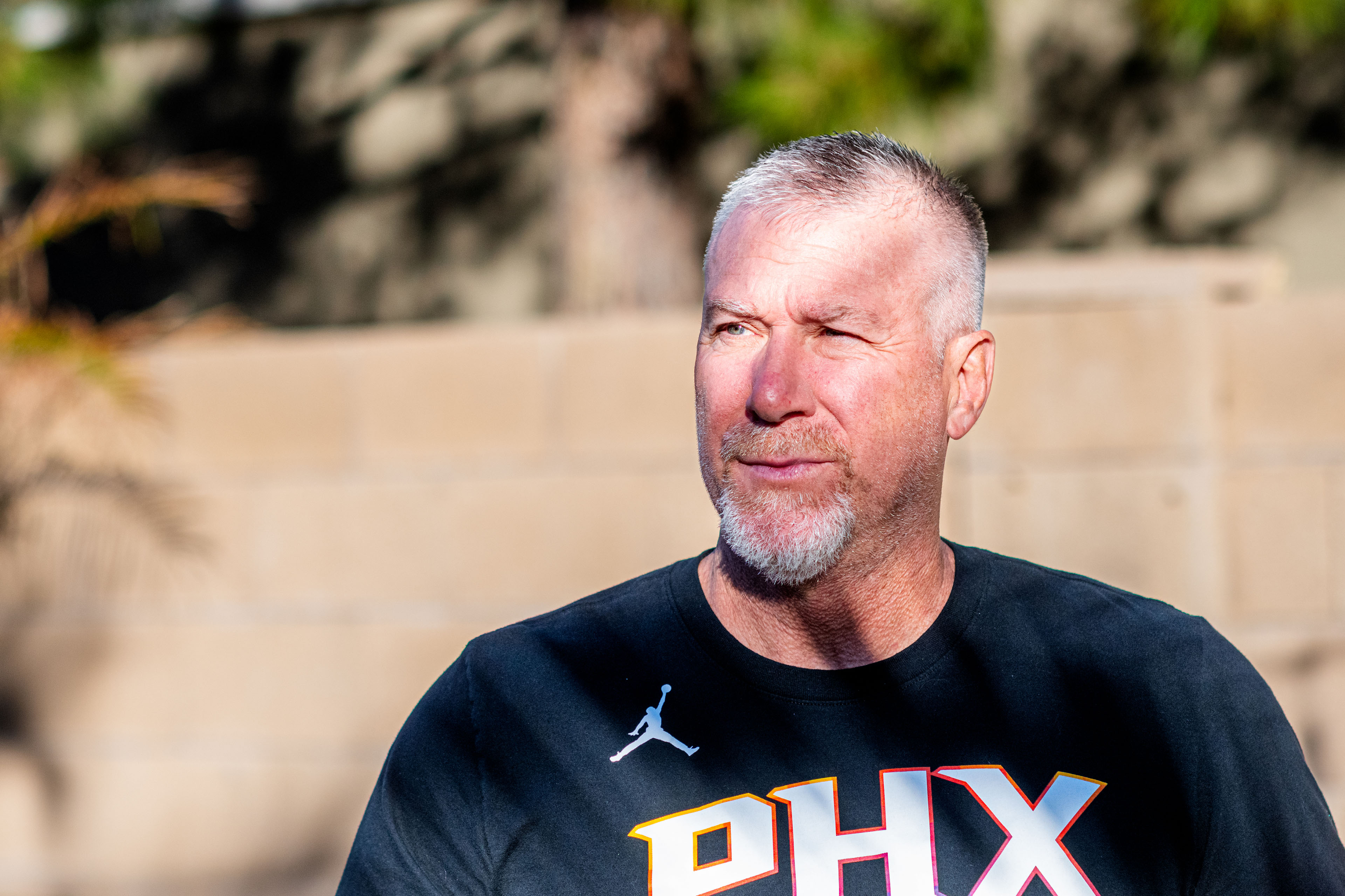 A portrait of a man standing outside.