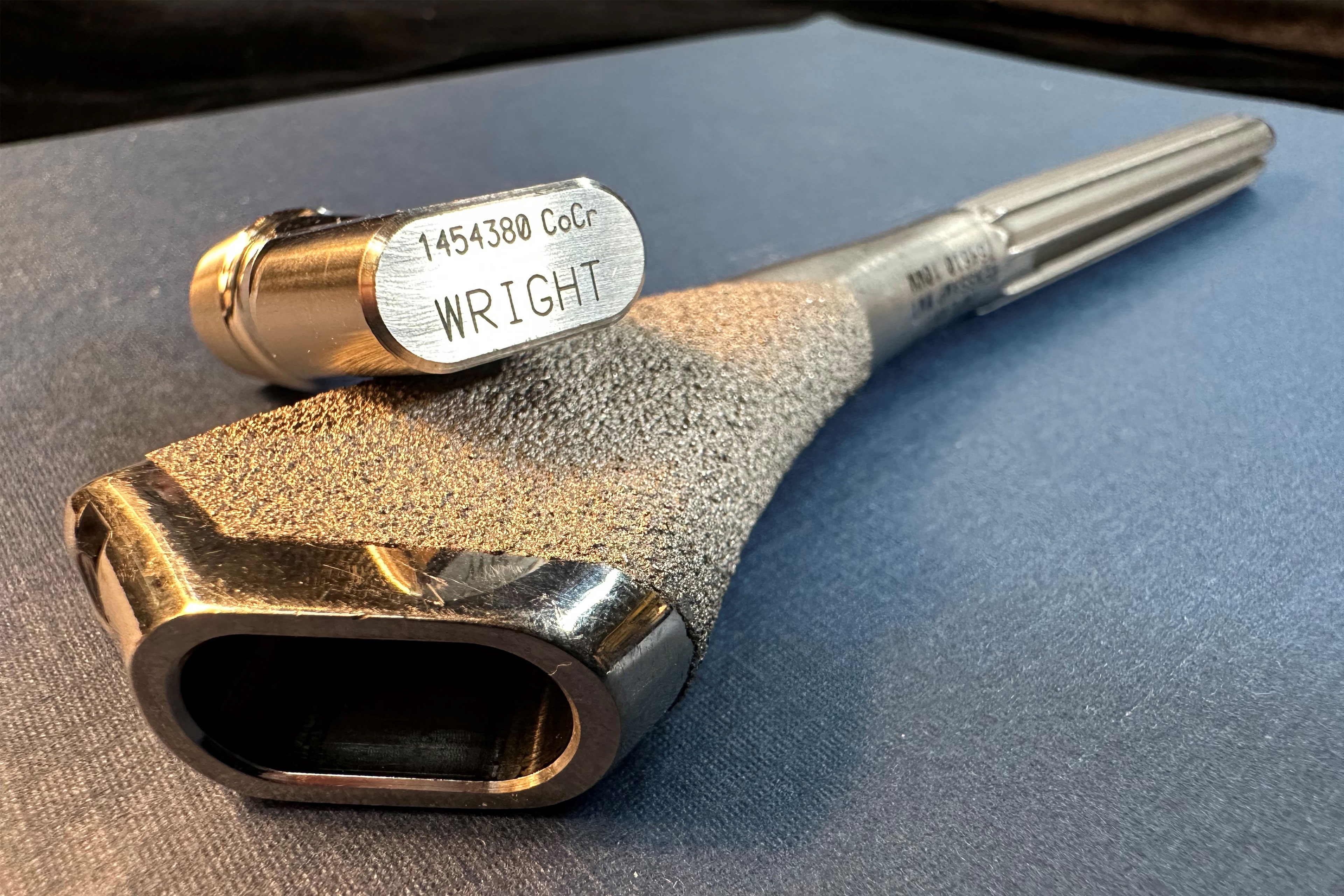 A photo of a Profemur implant resting on a flat surface.