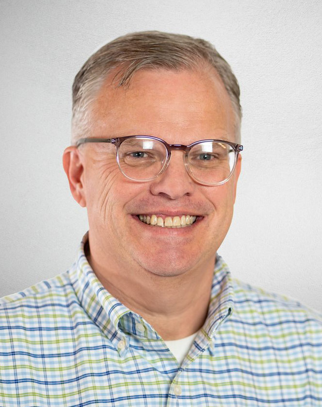 A photo of a man standing for a headshot.