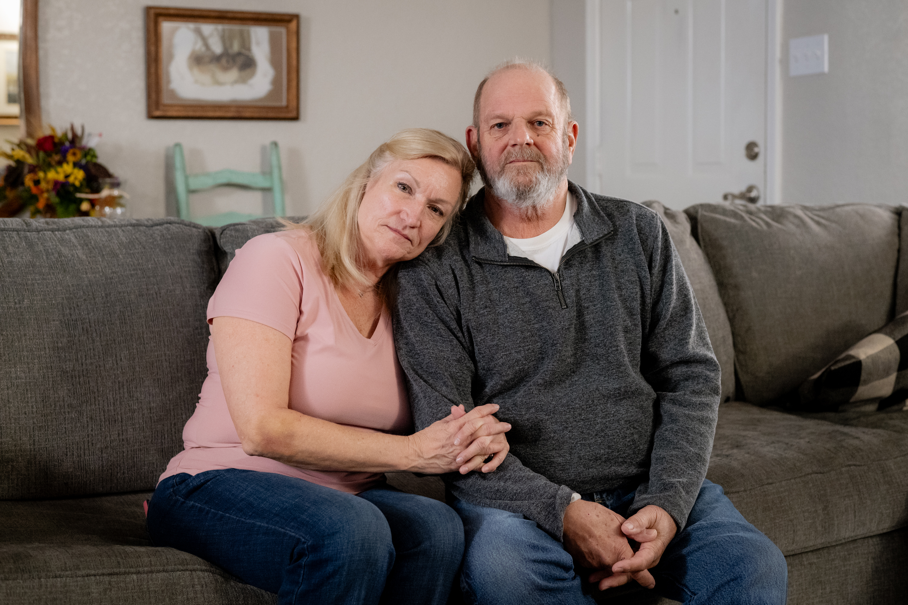 Ron and Teresa Winters sit on a touch together in their home.
