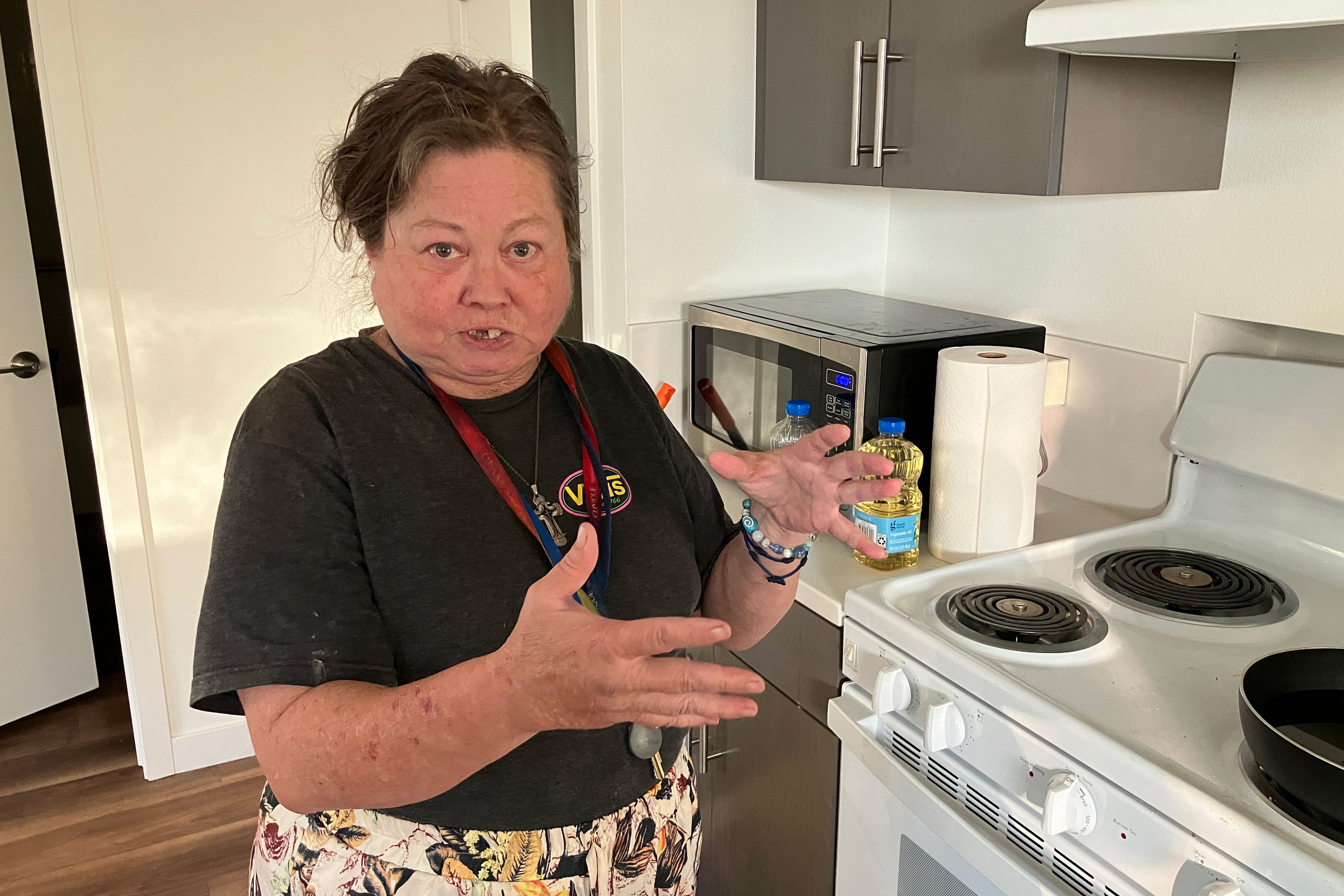 Carla Brown stands in the kitchen of her home and faces towards the camera.