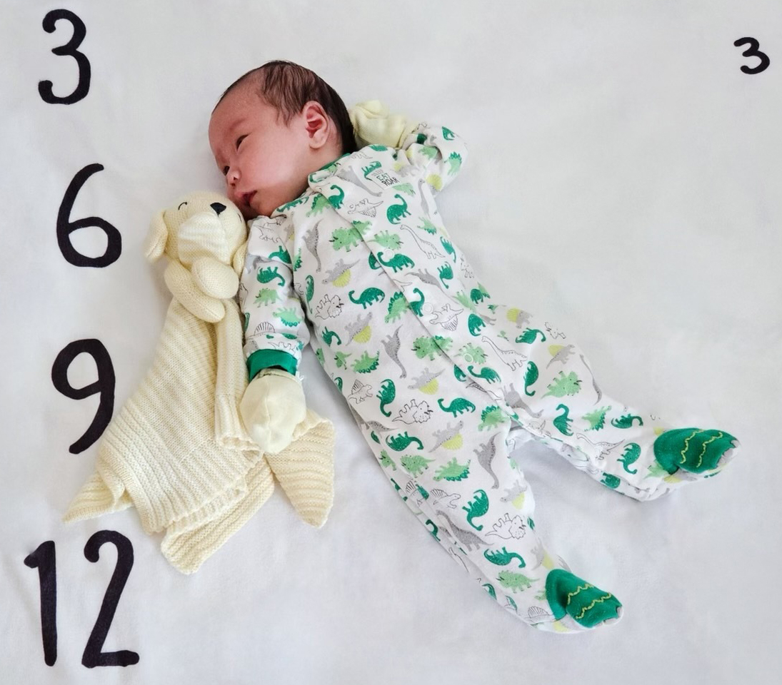 A photo of a 1-month-old baby lying down.
