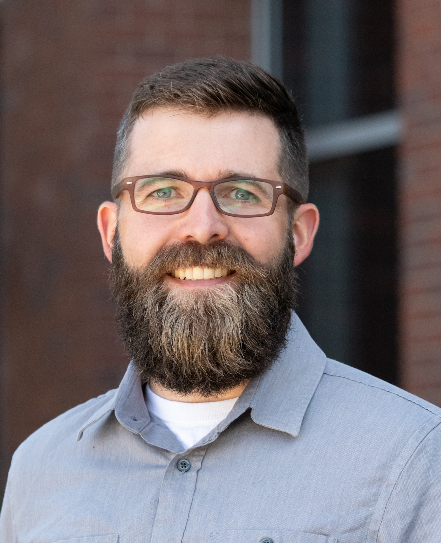 A portrait of a man standing outside.
