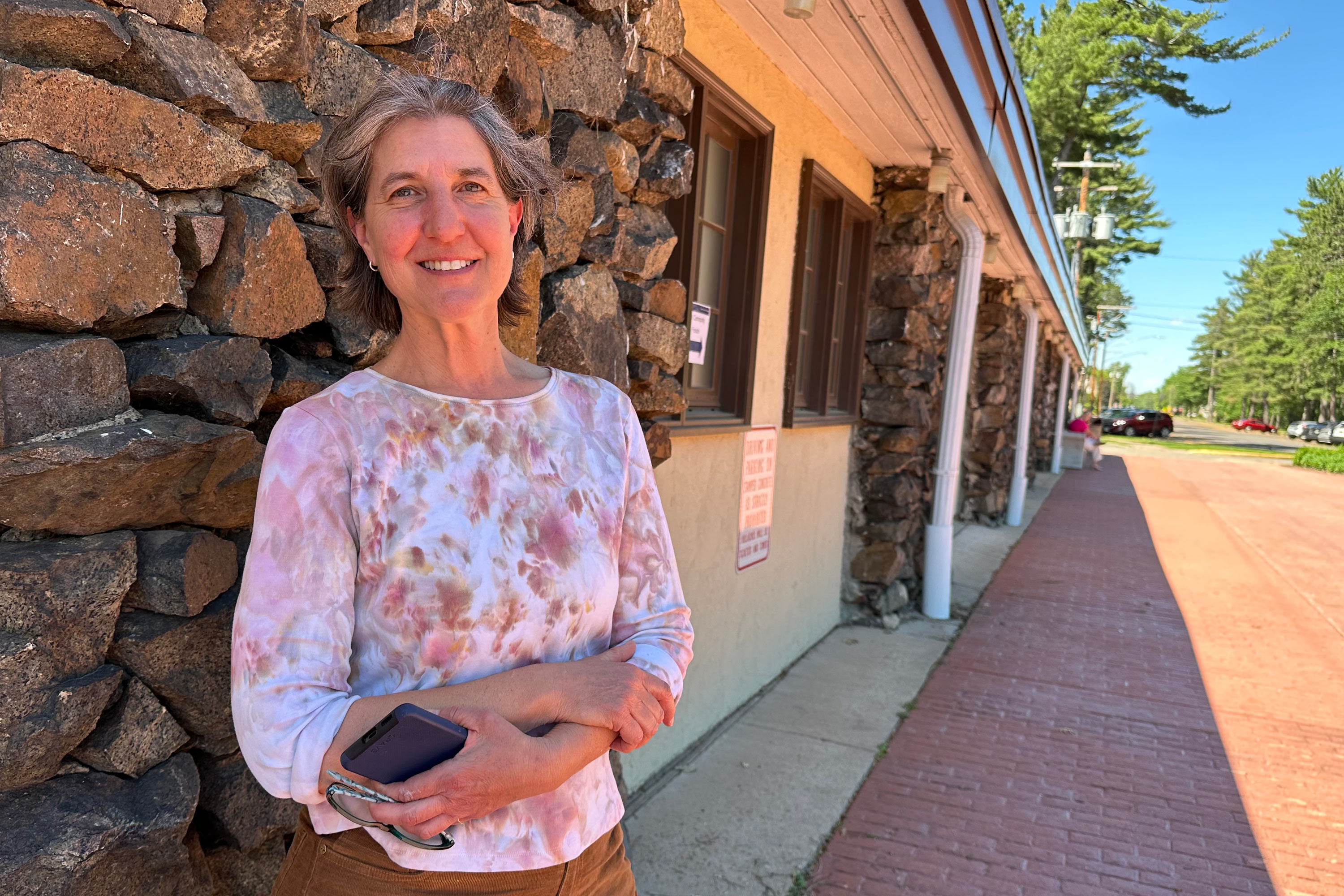 A photo of a woman posing for a photo outside.