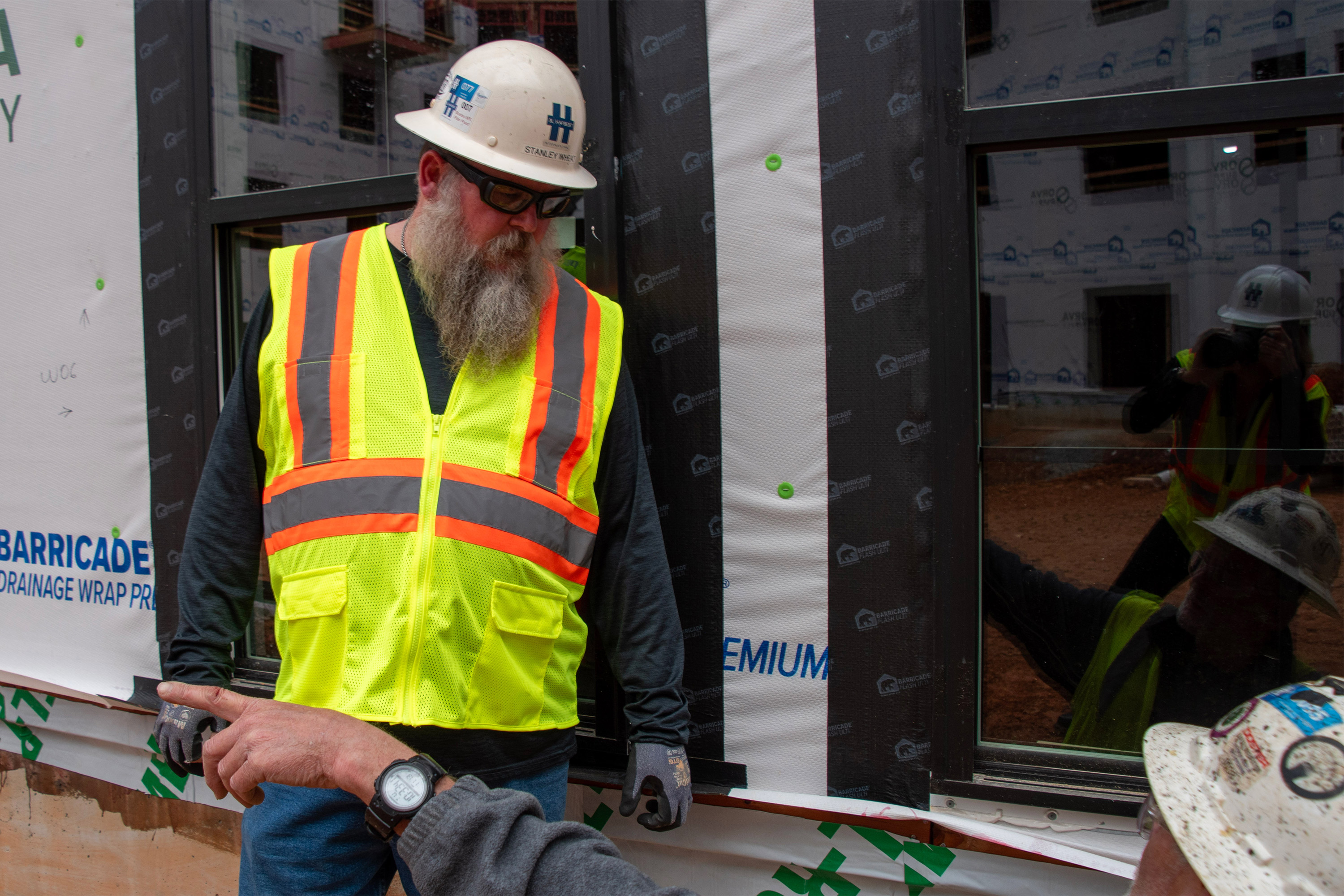 A photo of Stanley Wheat speaking to someone on a construction site.