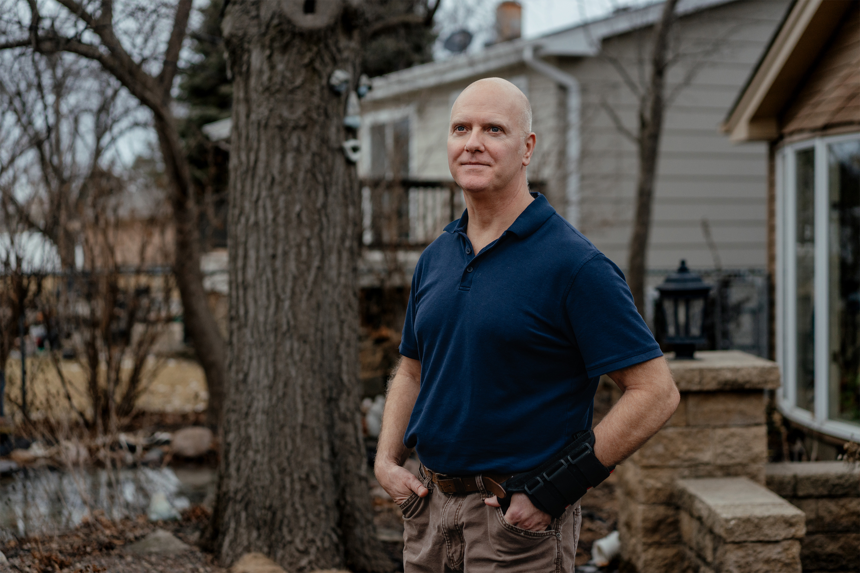 A photo of Tim Winard posing for a portrait outside his home.
