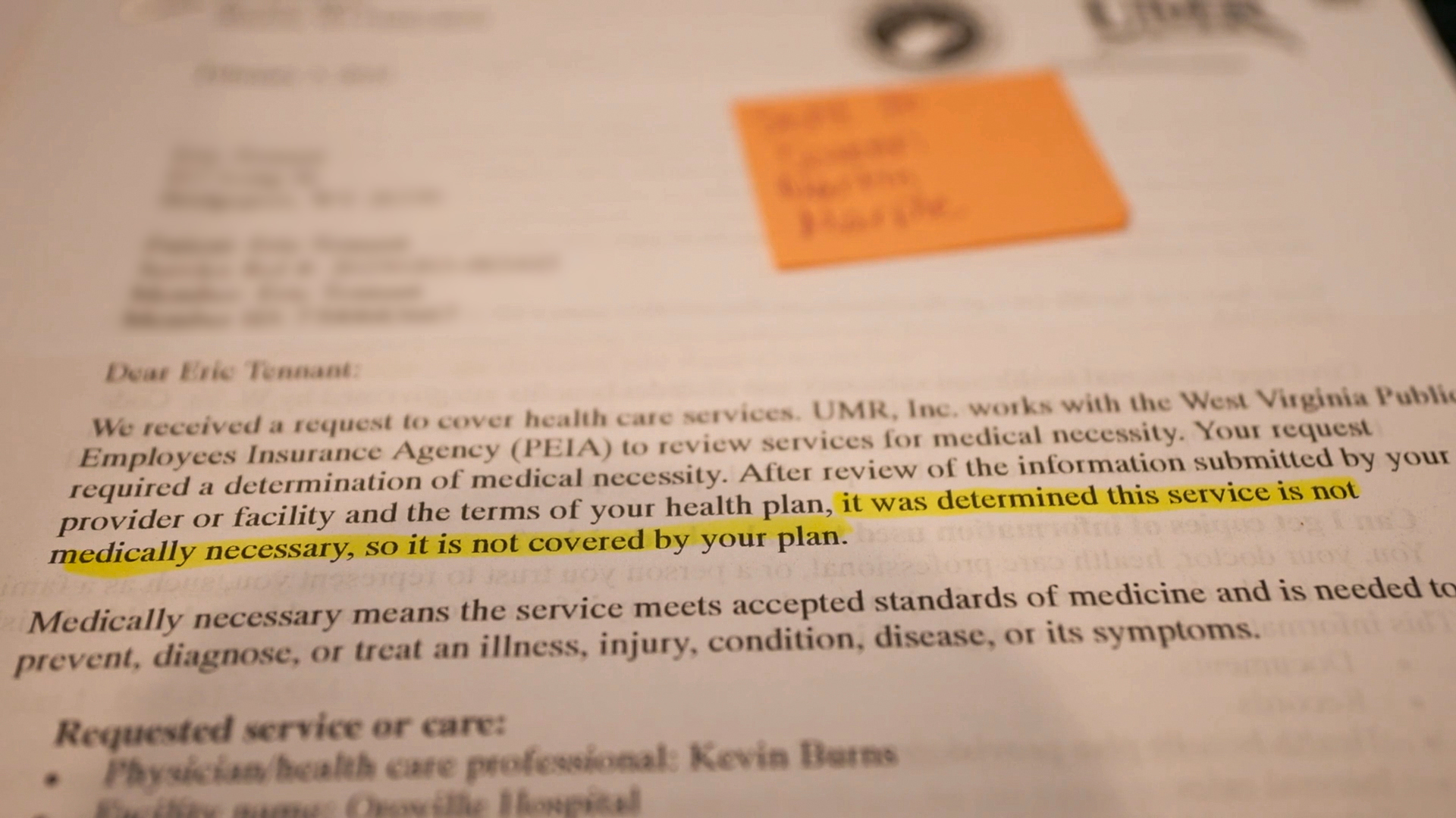 A photo of a denial letter with highlighted text that reads, "It was determined this service is not medically necessary, so it is not covered by your plan."