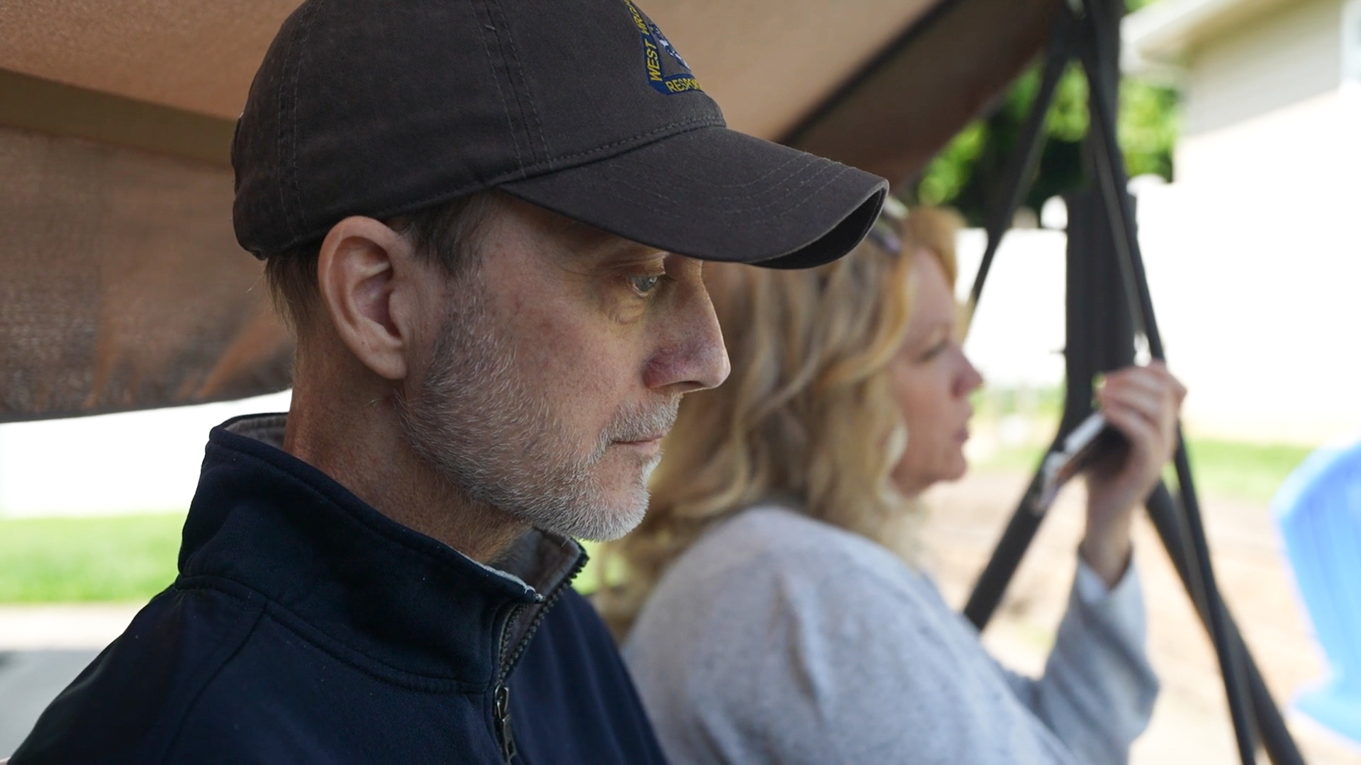 Eric Tennant sits on their back porch with his wife, Rebecca.