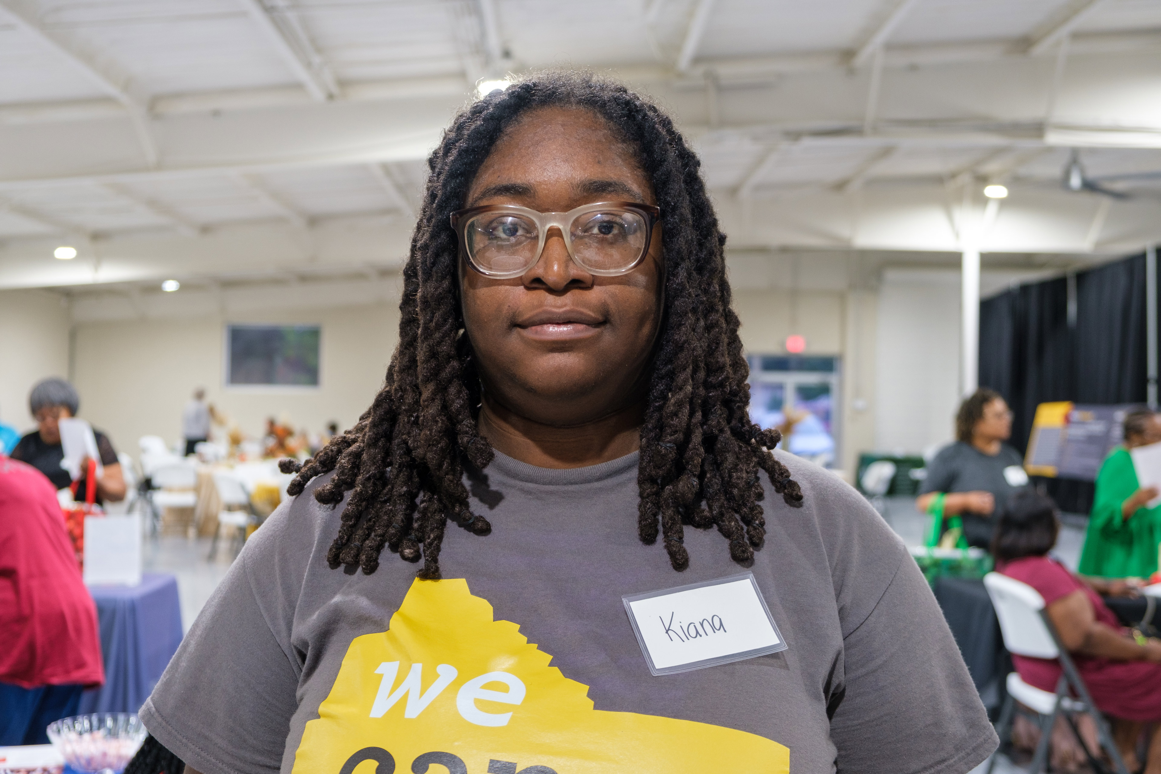 A photo of a Black woman standing for a photograph indoors.