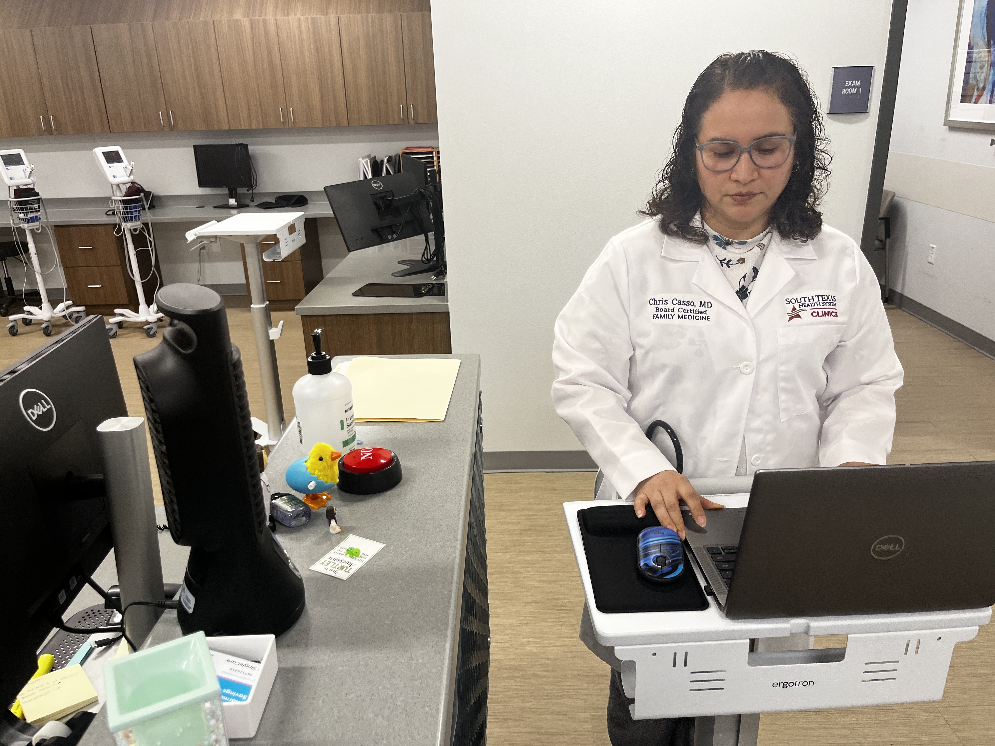 A photo of a Chris Casso working on a laptop in her office.