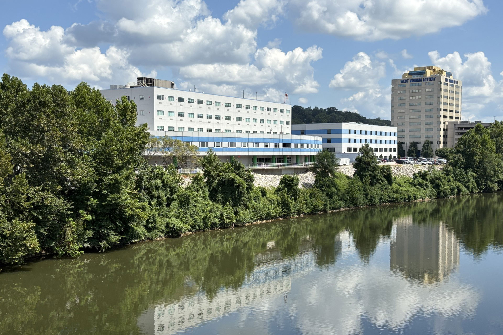 Several buildings can be seen on the banks of a river on slightly higher ground.