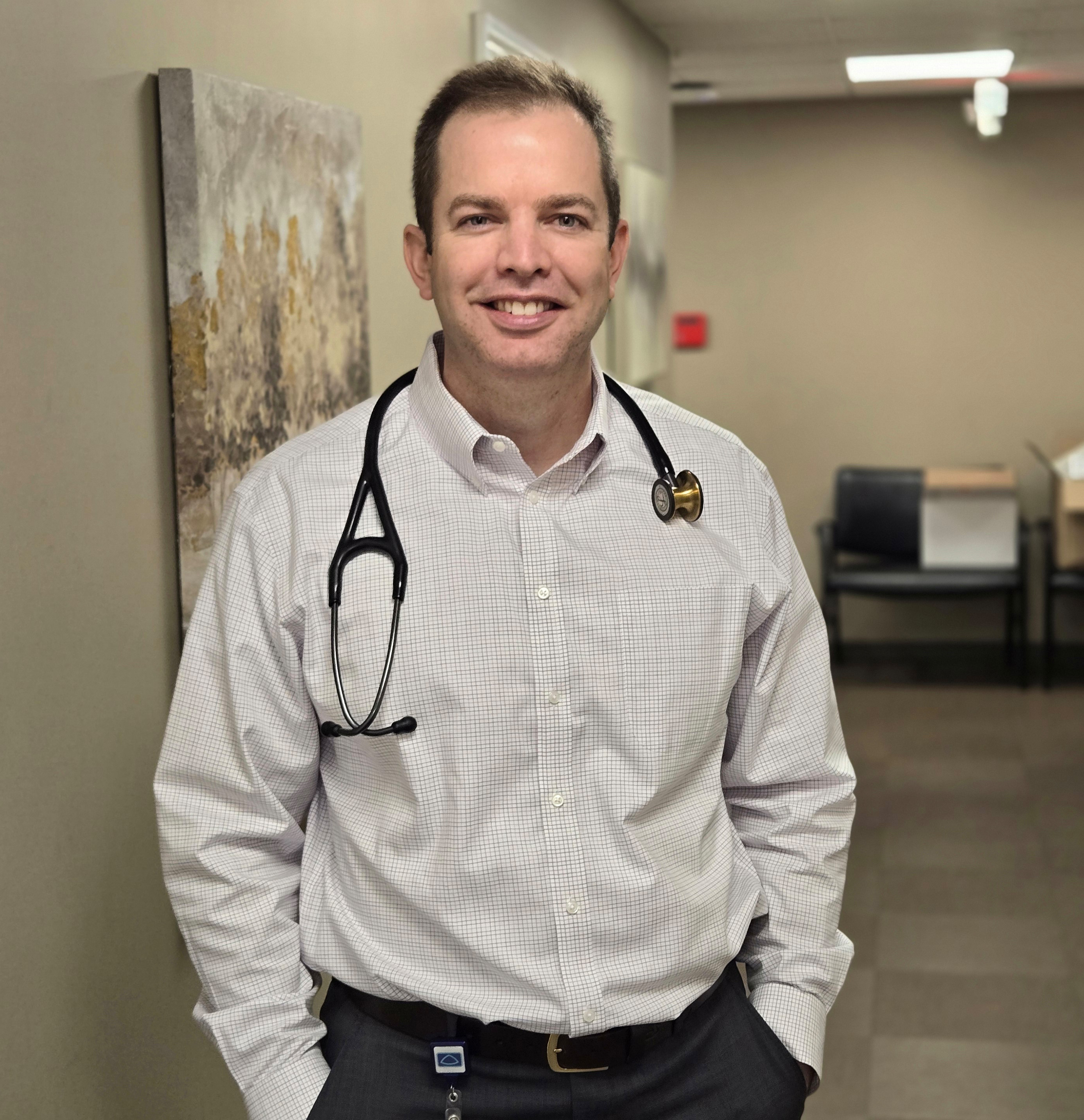 A photo of a doctor standing in a hallway.