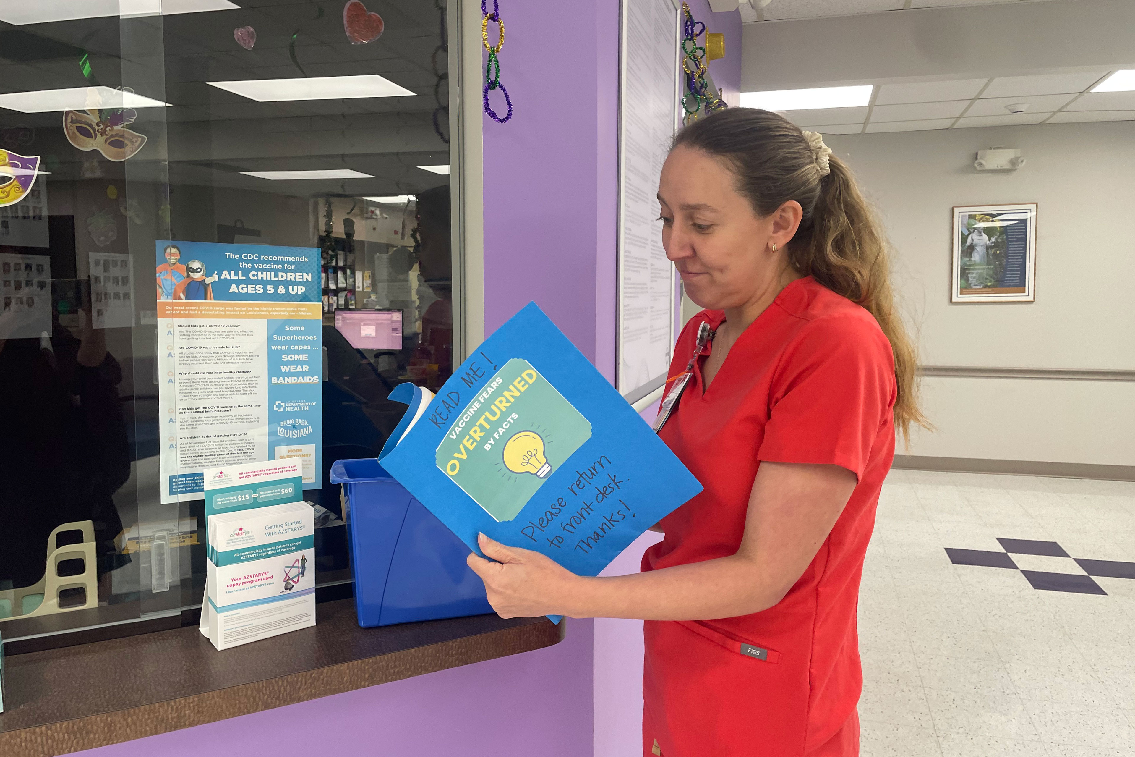 Mikki Bouquet looks through a blue folder inside a medical office.